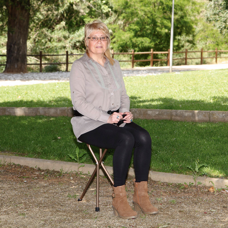 Bastón con asiento 3 patas Mujer sentada sobre bastón con asiento de tres patas