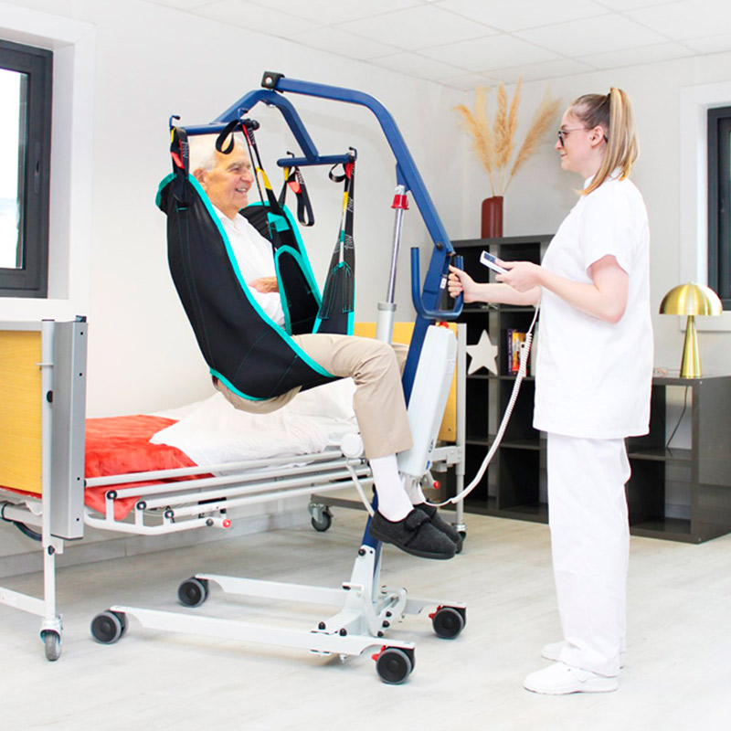 Grúa de Traslado Fly Grúa Fly Compact elevando a paciente desde la cama