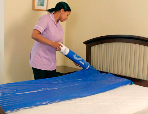 Sobrecolchón antiescaras Repose Enfermera inflando el sobrecolchón Repose en cama articulada
