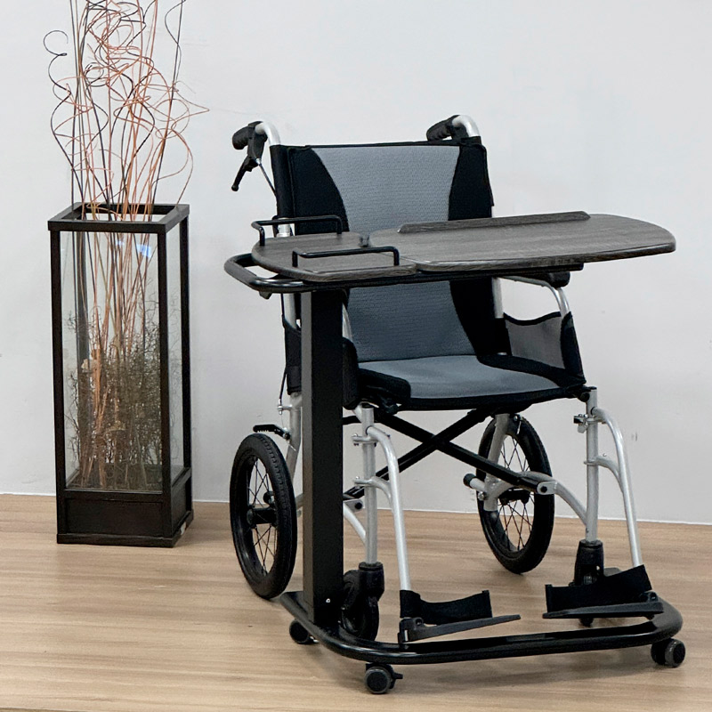 Mesa auxiliar doble plano Mesa auxiliar doble plano colocada frente a una silla de ruedas