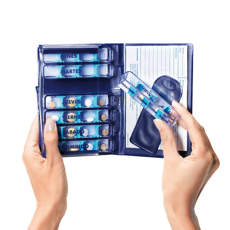Pastillero semanal medidos Estuche semanal abierto con recipientes de lunes a domingo; una persona extrae el módulo del miércoles