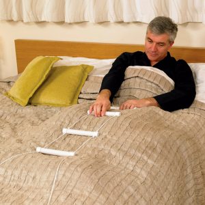 Hombre utilizando una escalerilla incorporador en la cama para levantarse