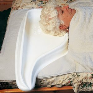 Persona encamada usando un lavacabezas de una sola pieza que conduce el agua a un cubo