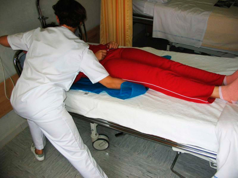 Sábana multideslizante HyperGlidetoo Enfermera utilizando sábana multideslizante HyperGlideToo para girar paciente en cama