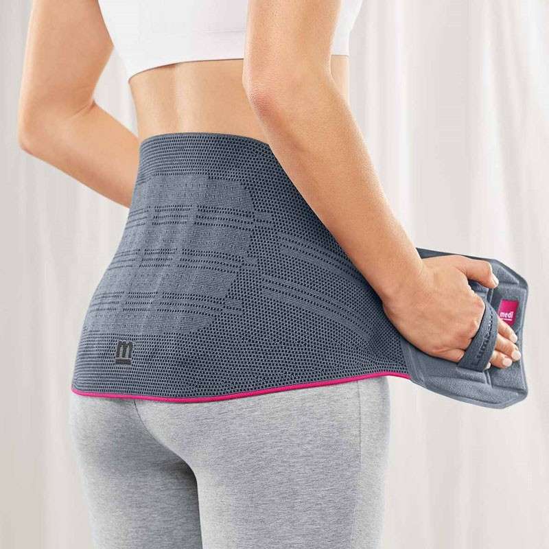 Faja lumbar Lumbamed Basic Persona colocando la faja lumbar Lumbamed Basic con correas para manos bilaterales