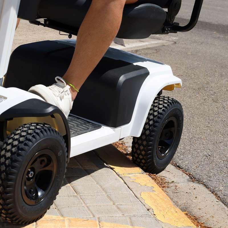 Scooter eléctrico Todoterreno K10073 Ruedas neumáticas del Scooter Eléctrico Todoterreno K10073 superando un bordillo